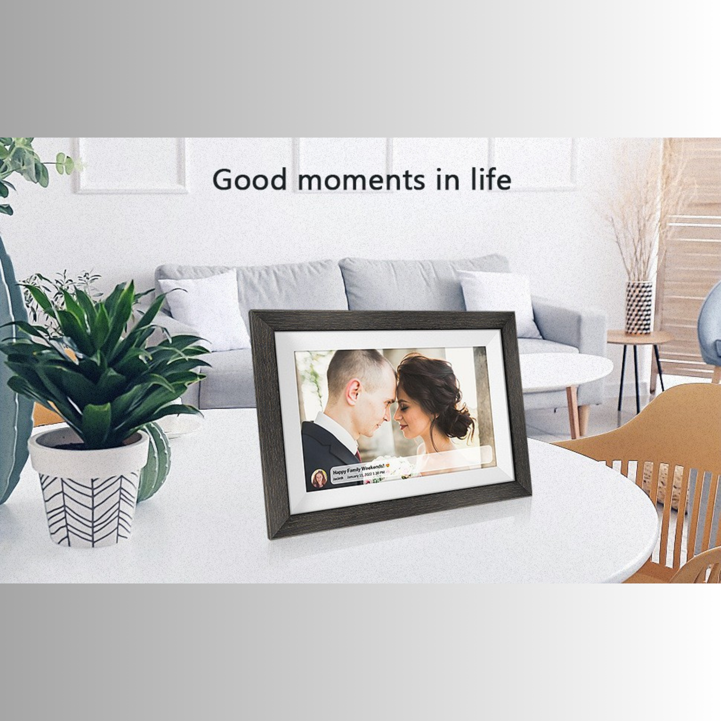 Pictura™ digital photo frame on a table displaying a couple's photo with text Good moments in life in a cosy home setting